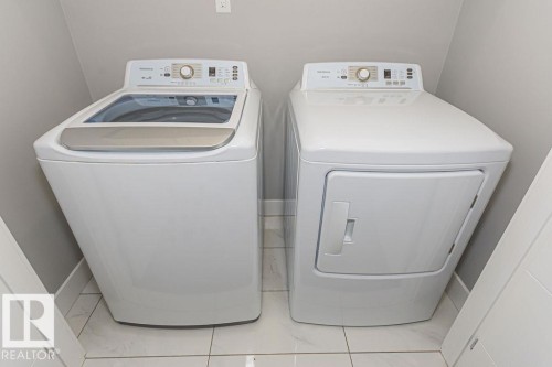 Laundry area featuring washing machine and dryer and baseboards - 1224 Mcconachie Boulevard, Edmonton, AB - Indoor Photo Showing Laundry Room
