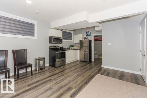 Kitchen featuring white cabinetry, stainless steel appliances, and dark wood finished floors - 1224 Mcconachie Boulevard, Edmonton, AB - Indoor Photo Showing Kitchen