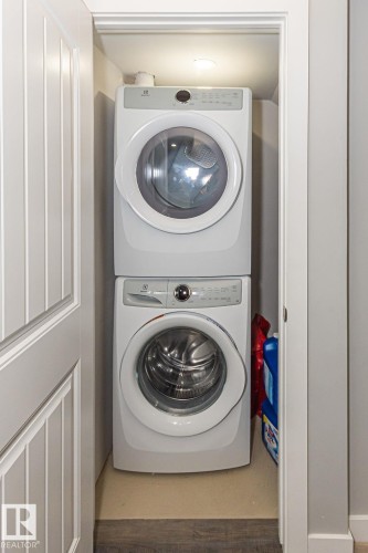 Laundry area with stacked washer and clothes dryer - 1224 Mcconachie Boulevard, Edmonton, AB - Indoor Photo Showing Laundry Room