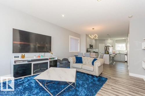 Living area with light wood-style floors and hanging lights - 1224 Mcconachie Boulevard, Edmonton, AB - Indoor Photo Showing Living Room