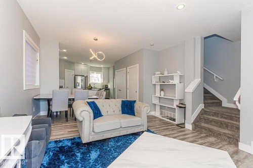 Living area with light wood-style floors and hanging lights - 1224 Mcconachie Boulevard, Edmonton, AB - Indoor Photo Showing Living Room