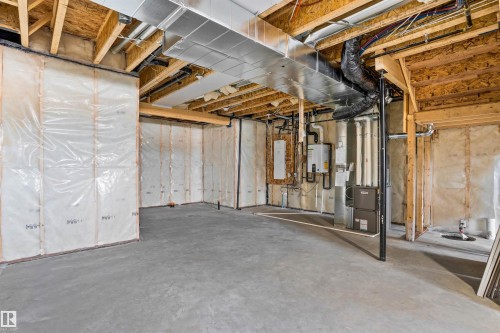 Unfinished below grade area with heating unit, water heater, and drainage system - 112 25 Street, Edmonton, AB - Indoor Photo Showing Basement
