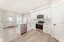 Kitchen featuring stainless steel appliances, white cabinetry, light wood-style flooring, a peninsula, and recessed lighting - 135 Pierwyck Loop, Spruce Grove, AB  - Indoor Photo Showing Kitchen 