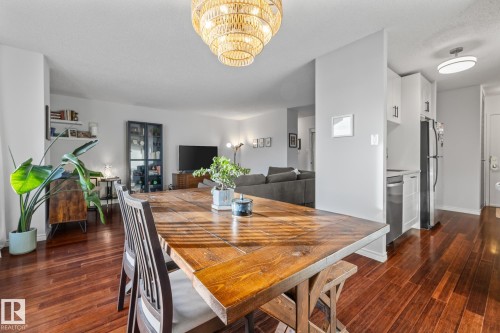Dining space featuring dark wood-style floors and a chandelier - 1502 9909 110 Street, Edmonton, AB - Indoor Photo Showing Dining Room