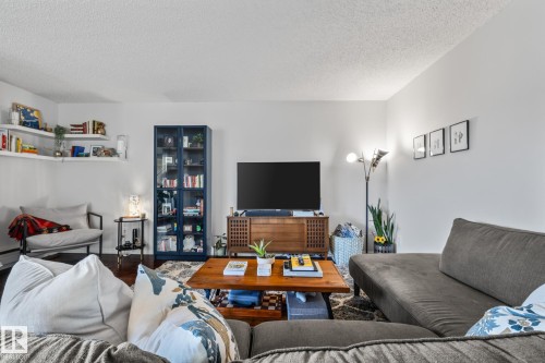 Living room with a textured ceiling and wood finished floors - 1502 9909 110 Street, Edmonton, AB - Indoor Photo Showing Living Room
