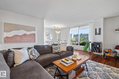 Living room featuring dark wood finished floors and a textured ceiling - 1502 9909 110 Street, Edmonton, AB - Indoor Photo Showing Living Room