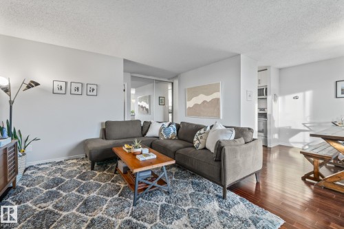 Living room with a textured ceiling and dark wood-type flooring - 1502 9909 110 Street, Edmonton, AB - Indoor Photo Showing Living Room