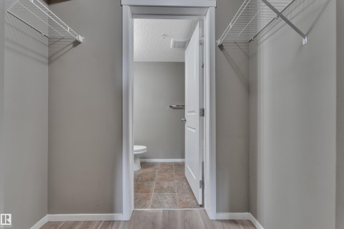 Walk in closet with light wood-style flooring - 216 5804 Mullen Place, Edmonton, AB - Indoor