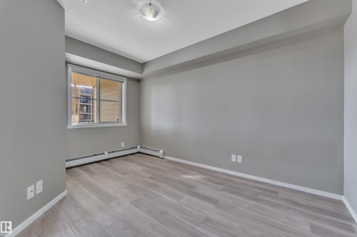 Unfurnished room with light wood finished floors and a textured ceiling - 216 5804 Mullen Place, Edmonton, AB - Indoor Photo Showing Other Room