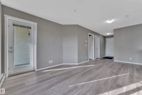 Spare room with light wood-style floors and a baseboard heating unit - 216 5804 Mullen Place, Edmonton, AB - Indoor Photo Showing Other Room