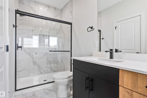 Full bath featuring vanity, a marble finish shower, and light marble finish flooring - 116 25 Street, Edmonton, AB - Indoor Photo Showing Bathroom
