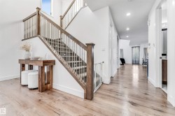 Stairs with hardwood / wood-style flooring, recessed lighting, and a high ceiling - 