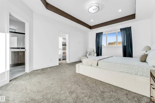 Bedroom with a tray ceiling, light carpet, and recessed lighting - 1407 Graydon Hill Way, Edmonton, AB - Indoor Photo Showing Bedroom