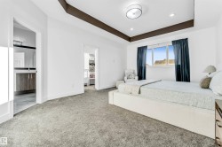 Bedroom with a tray ceiling, light carpet, and recessed lighting - 