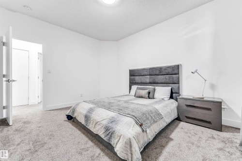 Carpeted bedroom featuring baseboards and a textured ceiling - 1407 Graydon Hill Way, Edmonton, AB - Indoor Photo Showing Bedroom