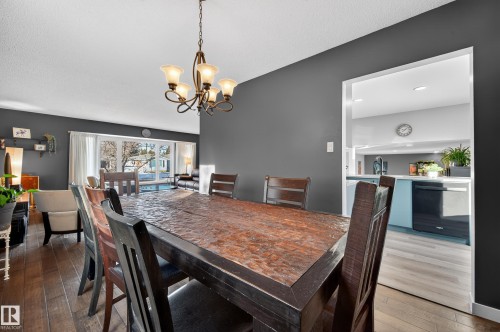 Dining room with dark wood-style flooring and suspended lighting - 9215 Ottewell Road, Edmonton, AB - Indoor Photo Showing Dining Room