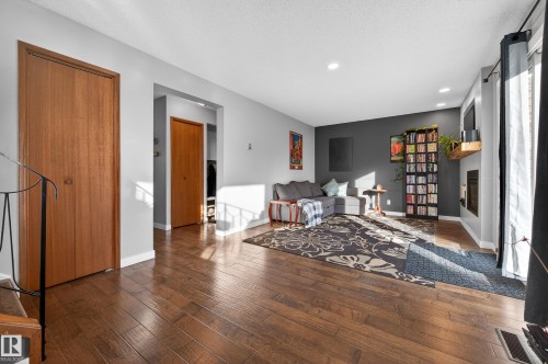 Sitting room with wood-type flooring, a glass covered fireplace, and recessed lighting - 9215 Ottewell Road, Edmonton, AB - Indoor