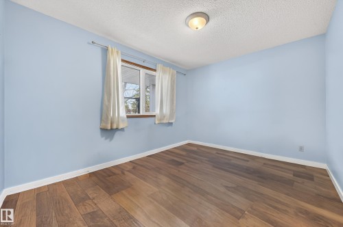 Spare room featuring dark wood-type flooring and a textured ceiling - 9215 Ottewell Road, Edmonton, AB - Indoor Photo Showing Other Room