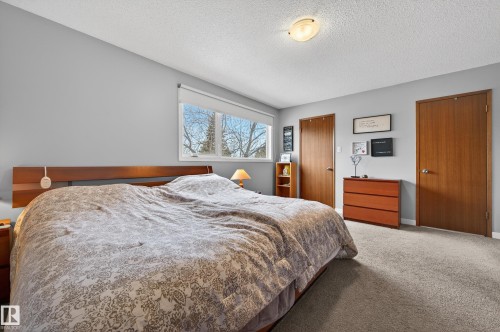 Carpeted bedroom with a textured ceiling and a closet - 9215 Ottewell Road, Edmonton, AB - Indoor Photo Showing Bedroom