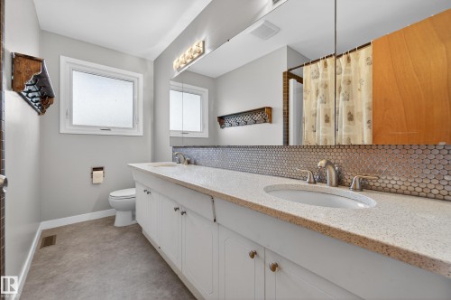Bathroom with double vanity, curtained shower, and backsplash - 9215 Ottewell Road, Edmonton, AB - Indoor Photo Showing Bathroom