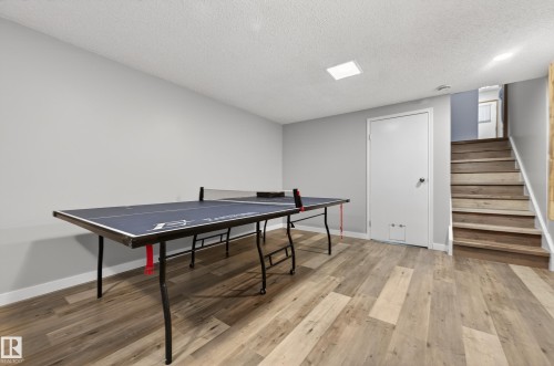 Game room with light wood-style flooring and a textured ceiling - 9215 Ottewell Road, Edmonton, AB - Indoor Photo Showing Other Room
