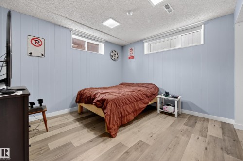 Bedroom featuring light wood-style flooring and wooden walls - 9215 Ottewell Road, Edmonton, AB - Indoor Photo Showing Bedroom