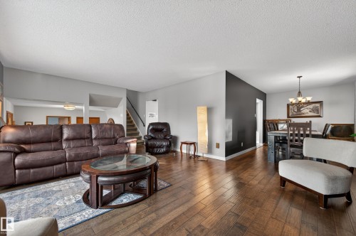 Living room featuring hardwood / wood-style flooring, a chandelier, and a textured ceiling - 9215 Ottewell Road, Edmonton, AB - Indoor Photo Showing Living Room