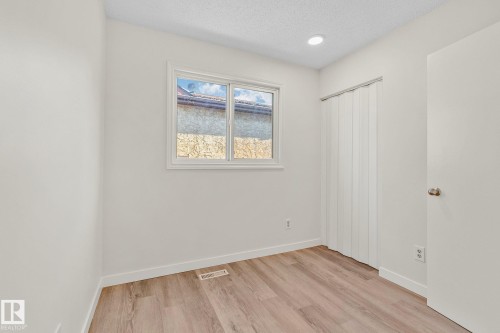Unfurnished bedroom with a textured ceiling, light wood-style flooring, and a closet - 4631 126 Avenue, Edmonton, AB - Indoor Photo Showing Other Room