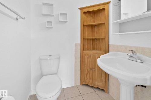 Half bath with light tile patterned flooring and toilet - 4631 126 Avenue, Edmonton, AB - Indoor Photo Showing Bathroom