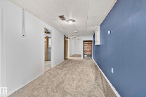 Hallway with a paneled ceiling, light colored carpet, and a barn door - 4631 126 Avenue, Edmonton, AB - Indoor Photo Showing Other Room