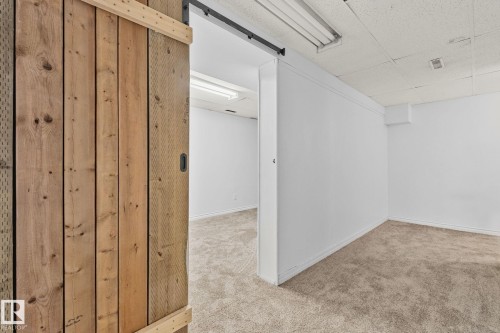 Finished basement with a barn door, a drop ceiling, and carpet - 4631 126 Avenue, Edmonton, AB - Indoor