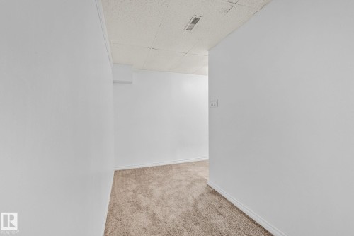 Empty room with a drop ceiling and carpet floors - 4631 126 Avenue, Edmonton, AB - Indoor