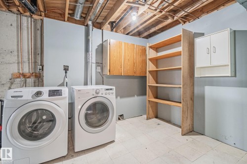 Laundry room featuring cabinet space, light floors, and independent washer and dryer - 4631 126 Avenue, Edmonton, AB - Indoor Photo Showing Laundry Room