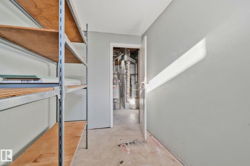 Corridor with concrete floors, water heater, and heating unit - 4631 126 Avenue, Edmonton, AB - Indoor