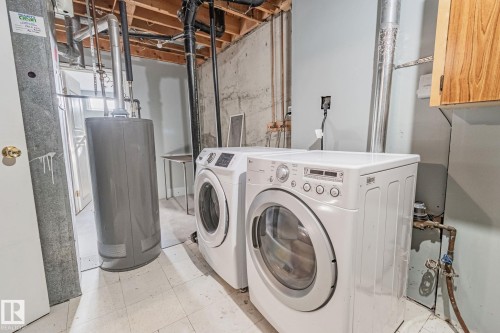 Laundry room featuring water heater and washing machine and dryer - 4631 126 Avenue, Edmonton, AB - Indoor Photo Showing Laundry Room