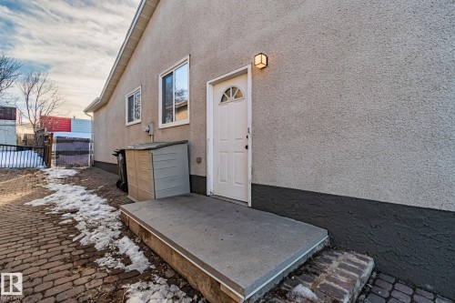 Property entrance featuring stucco siding, a patio, and a gate - 4631 126 Avenue, Edmonton, AB - Outdoor With Deck Patio Veranda