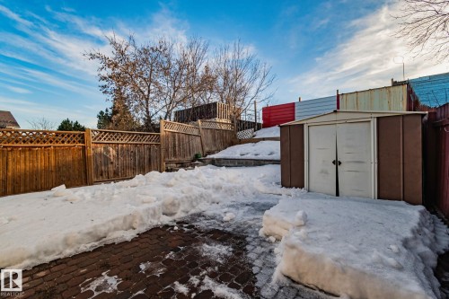 Yard layered in snow with a fenced backyard and a storage unit - 4631 126 Avenue, Edmonton, AB - Outdoor