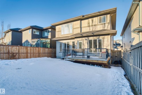 Snow covered rear of property featuring a fenced backyard and a deck - 2036 Ainslie Link Link, Edmonton, AB - Outdoor With Deck Patio Veranda