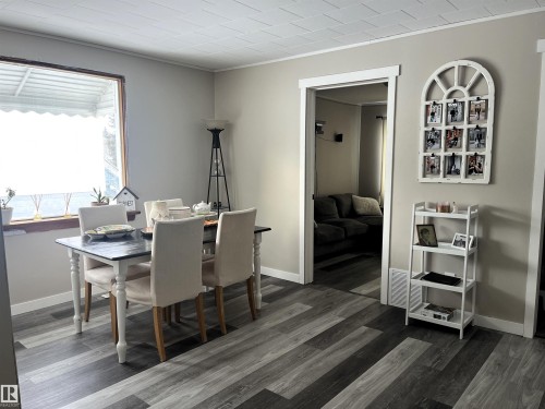Dining room with crown molding and dark wood-style flooring - 4811 48 Ave, Evansburg, AB - Indoor