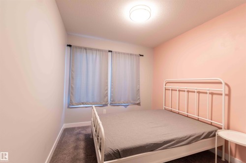 Bedroom with a textured ceiling and dark colored carpet - 21 1729 Keene Crescent, Edmonton, AB - Indoor Photo Showing Bedroom