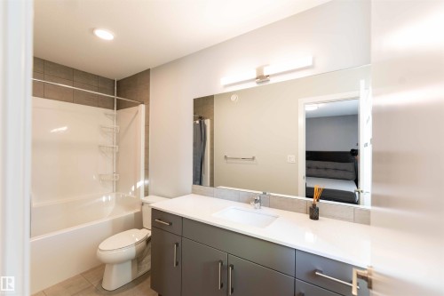 Full bath featuring vanity, shower / bathtub combination with curtain, ensuite bath, light tile patterned floors, and recessed lighting - 21 1729 Keene Crescent, Edmonton, AB - Indoor Photo Showing Bathroom