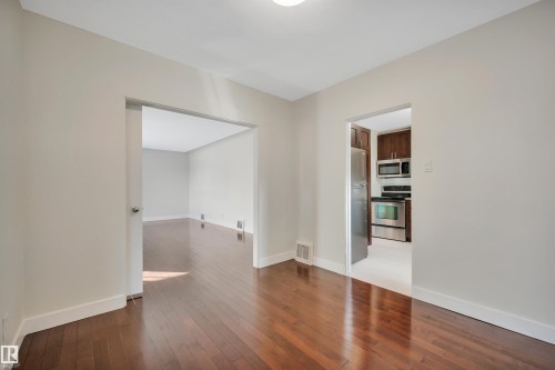 Empty room with dark wood-style flooring and baseboards - 6803 112A Street, Edmonton, AB - Indoor Photo Showing Other Room