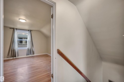 Additional living space featuring lofted ceiling and wood finished floors - 6803 112A Street, Edmonton, AB - Indoor Photo Showing Other Room