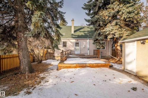 Rear view of property featuring a chimney, a deck, a fenced backyard, and roof with shingles - 6803 112A Street, Edmonton, AB - Outdoor