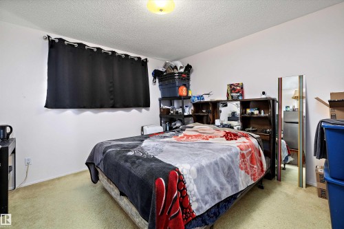 Bedroom with a textured ceiling and light carpet - 12117 91 Street, Edmonton, AB - Indoor Photo Showing Bedroom