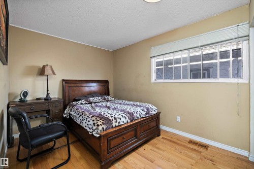 Bedroom featuring light wood-style floors and a textured ceiling - 12117 91 Street, Edmonton, AB - Indoor Photo Showing Bedroom