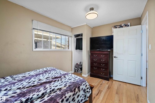 Bedroom with light wood-type flooring, a textured ceiling, and a closet - 12117 91 Street, Edmonton, AB - Indoor Photo Showing Bedroom