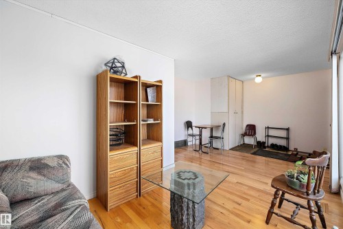 Living area with a textured ceiling and light wood-style flooring - 12117 91 Street, Edmonton, AB - Indoor