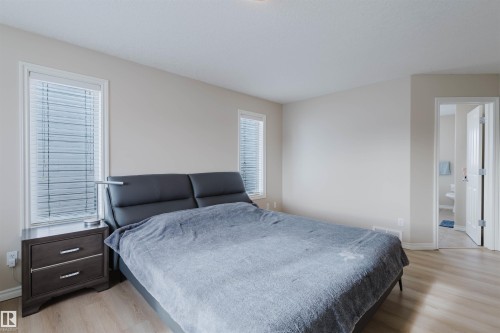 Bedroom featuring light wood finished floors and ensuite bath - 8420 Sloane Crescent, Edmonton, AB - Indoor Photo Showing Bedroom