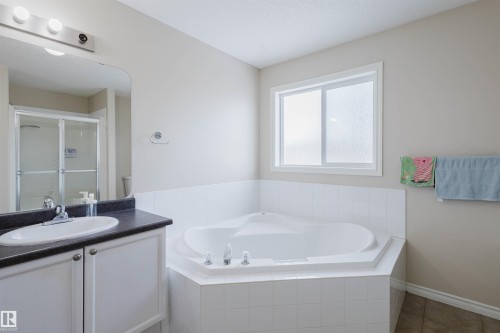 Bathroom with a garden tub, a stall shower, vanity, and tile patterned flooring - 8420 Sloane Crescent, Edmonton, AB - Indoor Photo Showing Bathroom